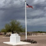 Florence Memorial Park Cemetery with Americal flag in the middle with gravestones behind it.