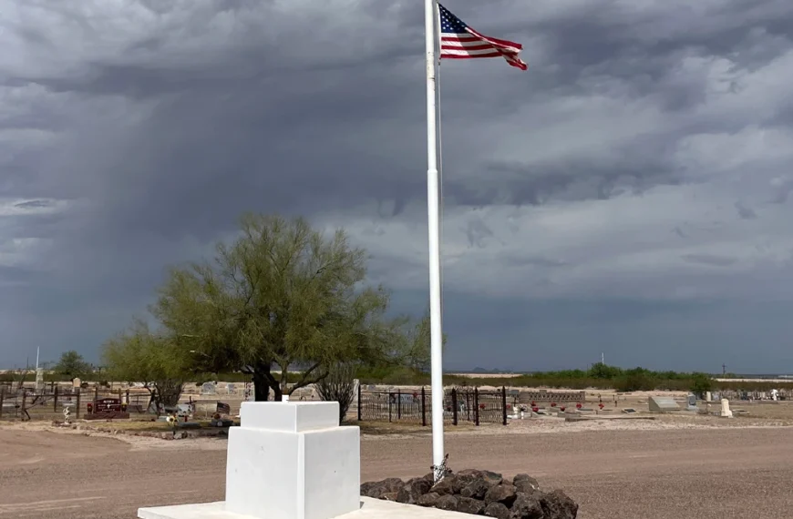 Florence Memorial Park Cemetery with American flag in the middle with gravestones behind it.