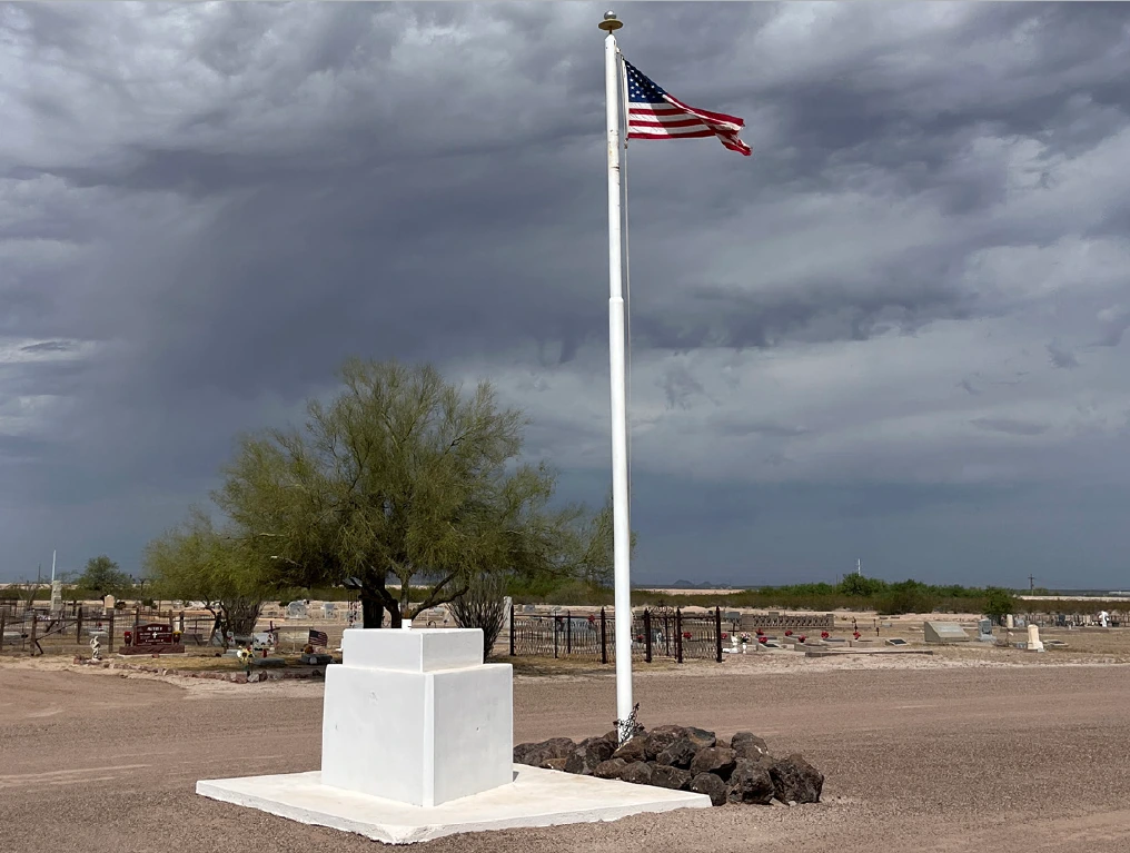 Florence Memorial Park Cemetery with American flag in the middle with gravestones behind it.