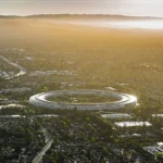 Aerial view of Apple Park's circular headquarters, nicknamed 'the spaceship,' at sunset in Cupertino, California.