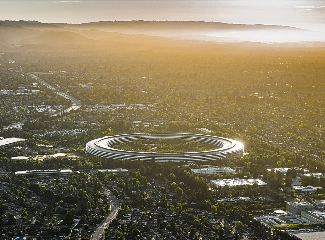 Aerial view of Apple Park's circular headquarters, nicknamed 'the spaceship,' at sunset in Cupertino, California.