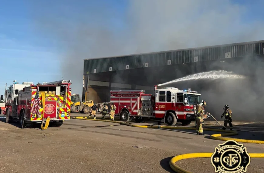 Fire engines and firefighters respond to the WM transfer station fire in Casa Grande, spraying water into a smoke-filled loading bay.