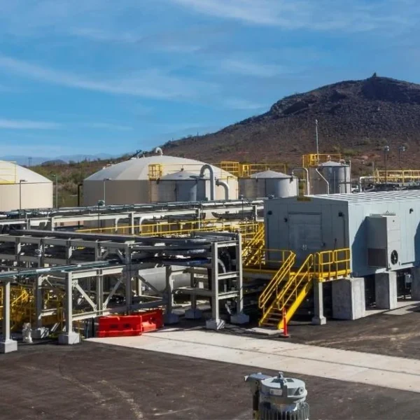 Storage tanks, piping and processing buildings at the Florence Copper facility, with Poston Butte rising in the background.