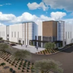 Conceptual rendering of a Project Midway data center building with white and gray panels, wood-tone accents, a glass entrance with a canopy, desert landscaping, and a parking lot